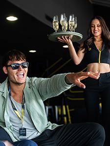 Gasten genieten van een privé motorsportervaring in een VIP-lounge.