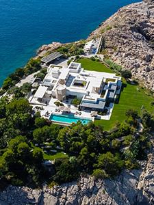 Luchtfoto van een luxe privévilla met zwembad en toegang tot zee, omringd door groen.