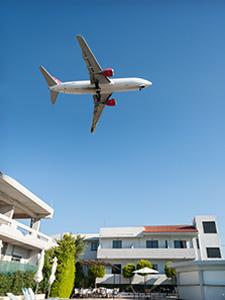 Passagiersvliegtuig vliegt boven daken – geregeld voor groepsreizen.