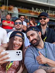 Fans maken een selfie en genieten van de sfeer op de tribune.