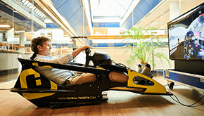 Un hombre usando un simulador de F1 con el logo de Global-Tickets